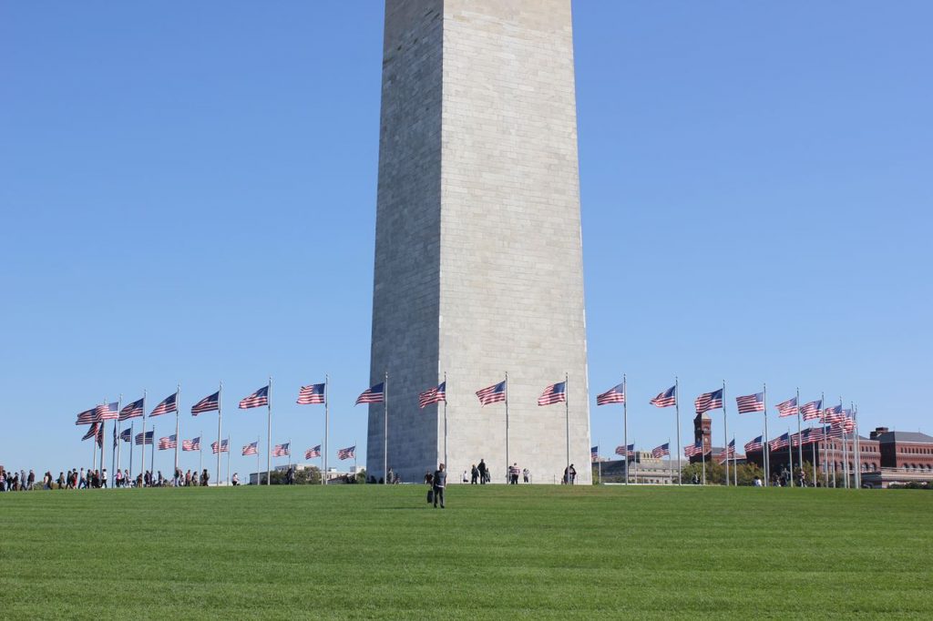 photo du Washington monument à Washington avec des drapeaux américains en dessous